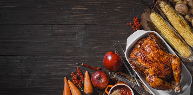 Baked chicken and baked corn. family dinner table. baked chicken and vegetables with glasses of cider. delicious rustic dinner