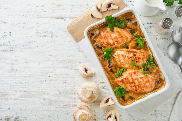 Baked chicken breast bbq with mushrooms and garlic in cream sauce on white wooden table backgrounds Top view image with ingredients for cooking Top view with copy space