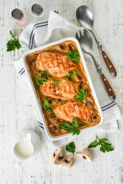 baked chicken breast bbq with mushrooms and garlic in cream sauce on white wooden table backgrounds top view image with ingredients for cooking top view with copy space