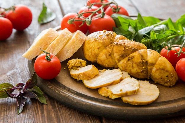 Baked chicken breast (Pastrami) with spices, tomato and basil. selective focus