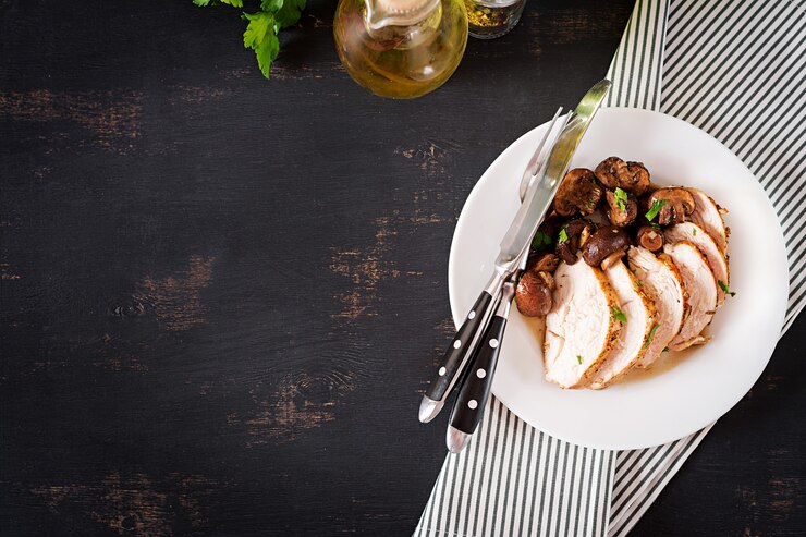 Photo baked chicken breast with mushrooms in balsamic  sauce  on the table. top view