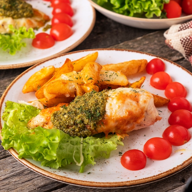 Baked chicken breast with pesto sauce and fresh cherry tomatoes