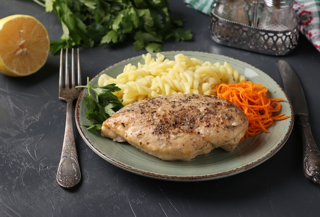 Baked chicken fillet, pasta and fresh carrots - a delicious and healthy breakfast