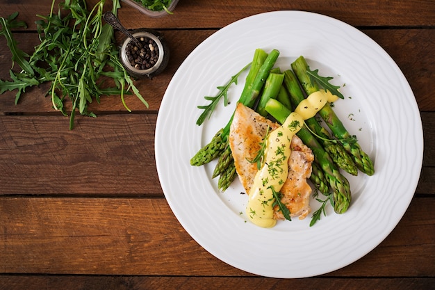 Baked chicken garnished with asparagus and herbs