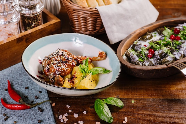 Baked chicken leg with sauce and fruits on the wooden background