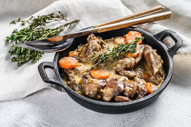 Baked Chicken liver, offal with onions  in a frying pan. White background. Top view.