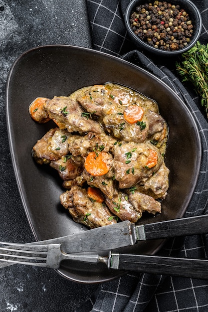 Photo baked chicken liver, offal with onions in a frying pan