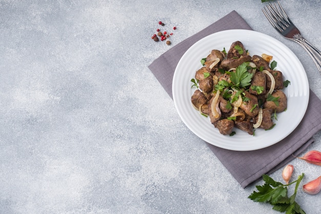 Baked chicken liver with onion on a plate.