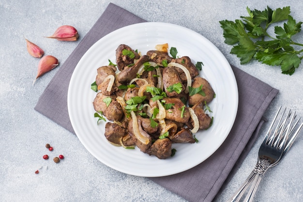 Baked chicken liver with onion on a plate