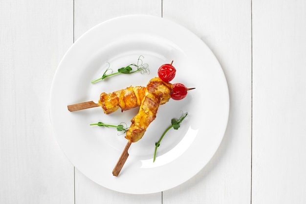 Baked chicken skewers with cherry tomatoes and greens