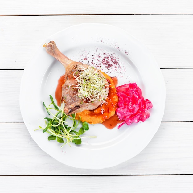 Baked chicken thigh with pumpkin puree. In the plate. Top view. Free space for your text. Rustic style.