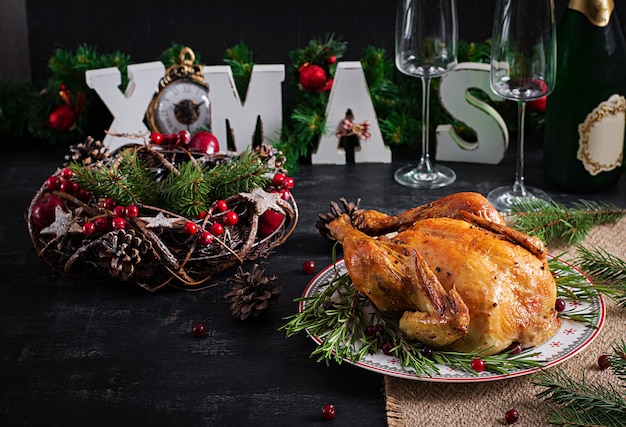 Photo baked  chicken or turkey. the christmas table is served with turkey, decorated with bright tinsel. fried chicken, table. christmas dinner. table setting. top view, above