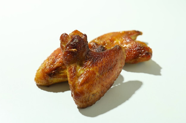 Baked chicken wings on white background, close up