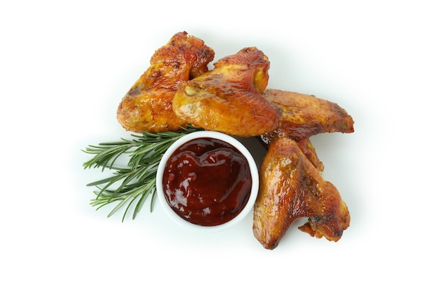 Baked chicken wings with rosemary and sauce isolated on white background