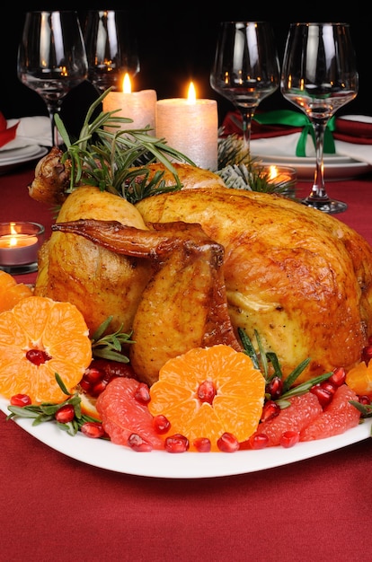 크리스마스 테이블에 만다린, 자몽, 석류를 곁들인 구운 치킨