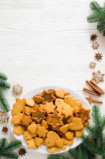 baked Christmas gingerbread ready to decorate with icing on white wooden background