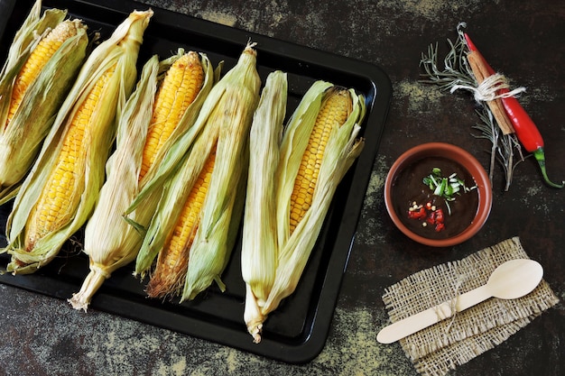 Baked corn in leaves on a pan