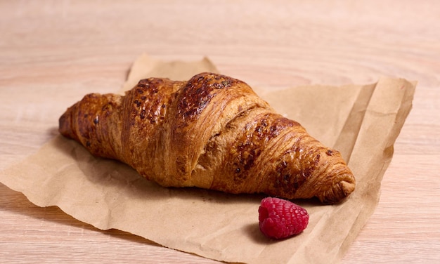 Baked crispy croissant on a wooden board breakfast