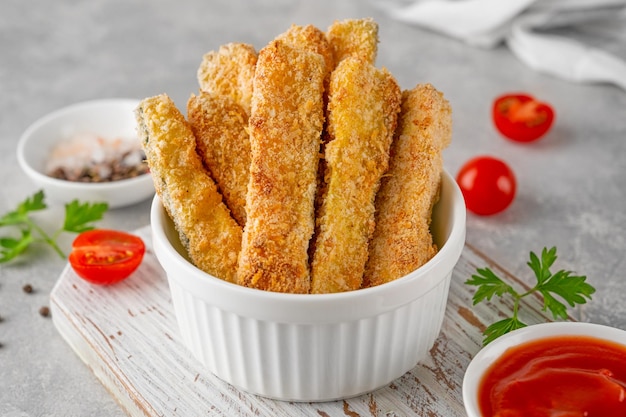 Baked crispy garlic parmesan zucchini sticks served with tomatoes sauce Vegetarian healthy dish