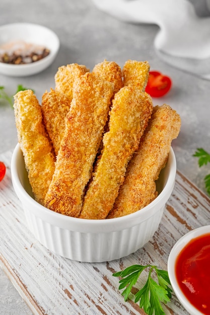 Baked crispy garlic parmesan zucchini sticks served with tomatoes sauce Vegetarian healthy dish