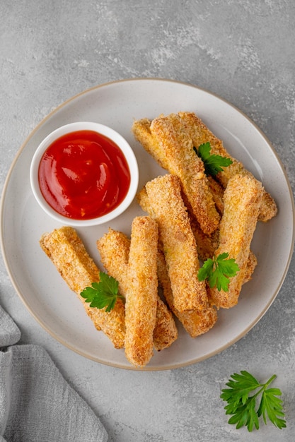 Baked crispy garlic parmesan zucchini sticks served with tomatoes sauce Vegetarian healthy dish