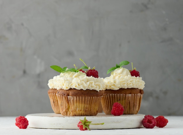 Фото Печенные кексы с белым сливочным кремом на столе вкусный десерт