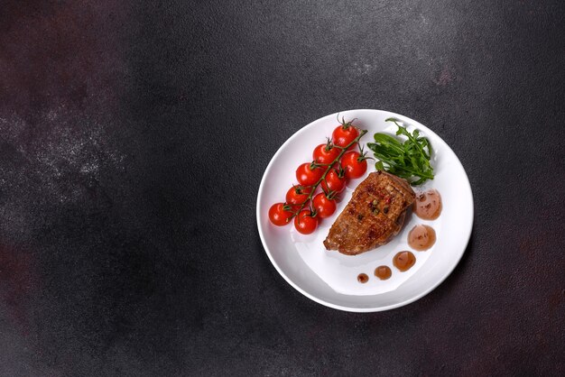暗いテーブルの上にハーブとスパイスを添えた焼き鴨胸肉。すぐに食べられる揚げ肉