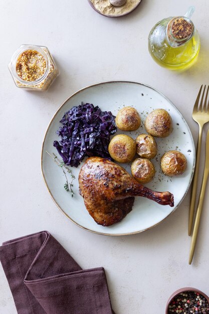 Baked duck leg with potatoes and red cabbage