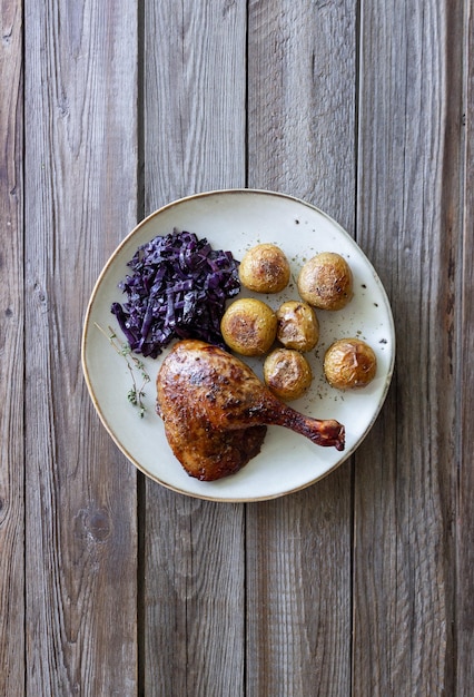 Baked duck leg with potatoes and red cabbage