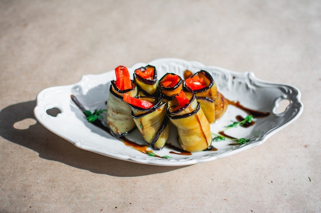 Baked eggplant rolls with chicken onions and carrots in a plate Closeup