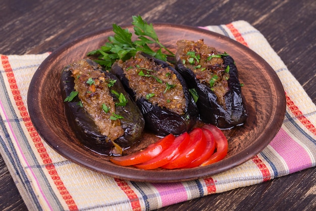 皿に玉ねぎチェリープラムとクルミを詰めた焼きナスの接写