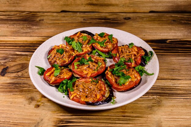 Photo baked eggplants with tomatoes and cheese in a ceramic plate