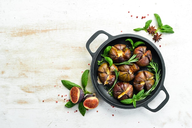 Baked figs with brie cheese and basil in a pan Free space for your text Top view