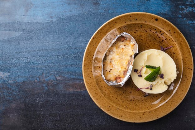 Baked fish under cheese with mushed potatoes on a plate Top view Space for text