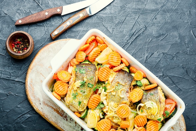 Photo baked fish steaks with grilled vegetables in a baking dish.