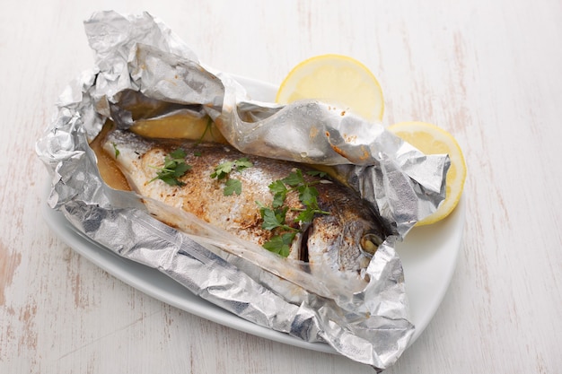 Baked fish with lemon in aluminium foil