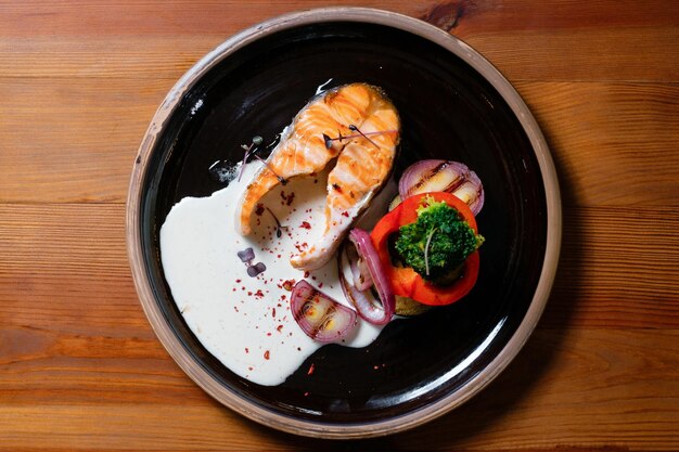 Baked fish with vegetables Grilled salmon on a black plate