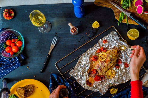 Baked fish with vegetables on the table with different vegetables and herbs The concept of healthy eating