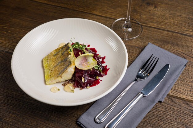 Photo baked fish with zucchini and dill on a white plate