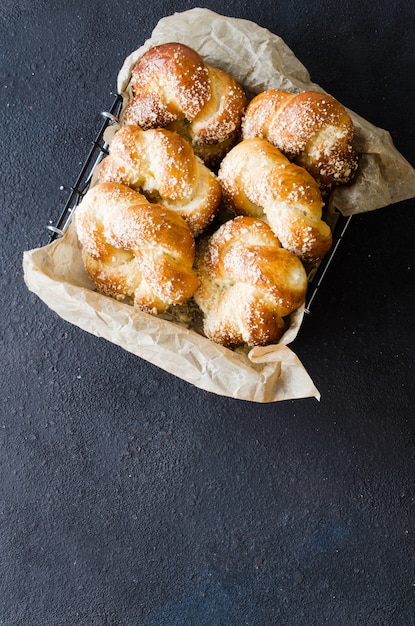 Baked fresh fragrant buns. Traditional homemade pastries. Pigtail buns top view.