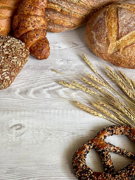 baked goods with ears of wheat on a gray wooden background, space for text