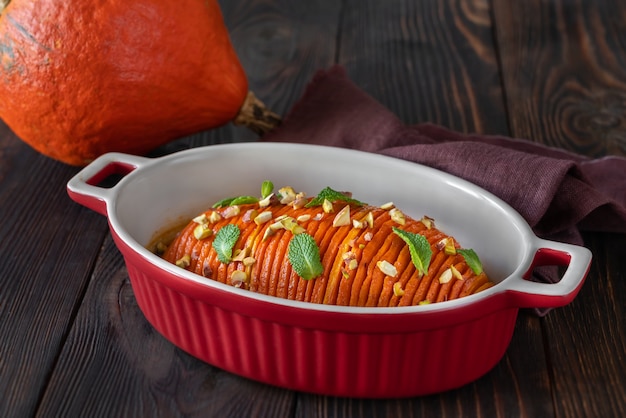 Baked hasselback pumpkin glazed with caramel in baking pan