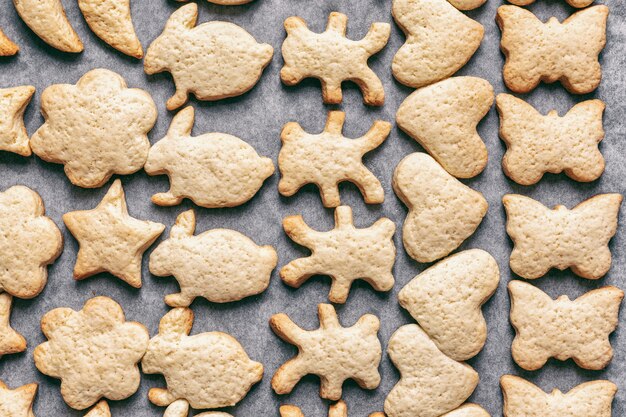 사진 양피지 공예 종이에 다양한 동물의 형태로 구운 홈메이드 쿠키, 크리스마스 또는 새해 간식, 위쪽 전망