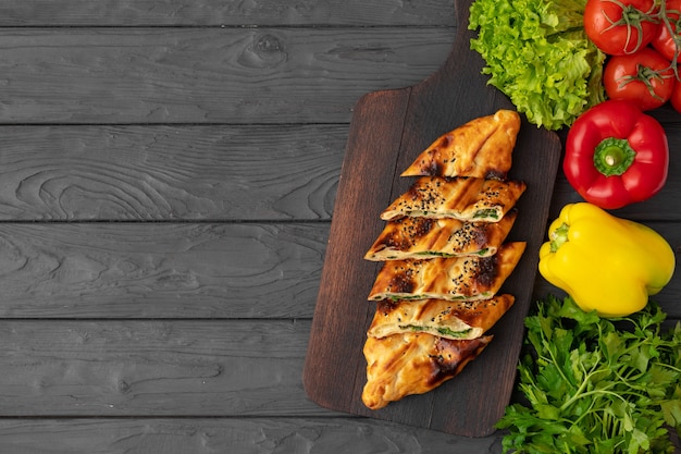 Baked homemade flatbread on wooden surface close up