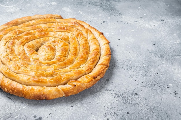 Baked homemade traditional Greek cheese pie on kitchen table Gray background Top view Copy space