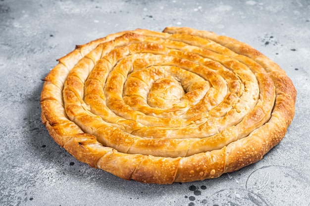 Baked homemade traditional Greek cheese pie on kitchen table Gray background Top view