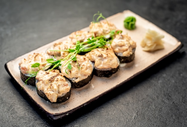 石の背景に焼きたての日本の巻き寿司はすぐに食べられます