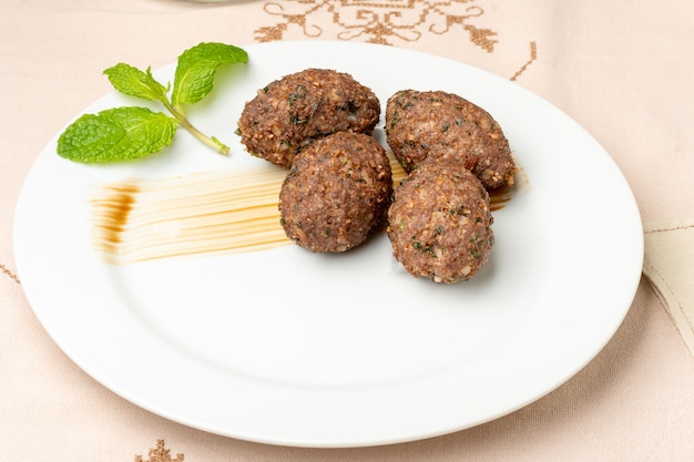 Foto kibbeh al forno su un piatto bianco cibo arabo