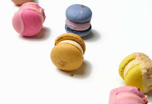 Baked macarons with different flavors on a white background, top view