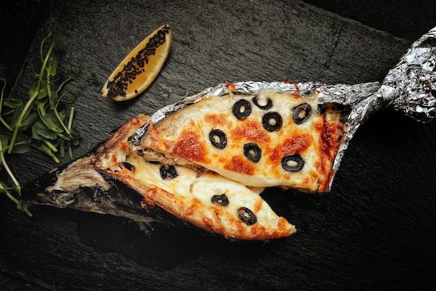 Baked mackerel stuffed with cheese with olives